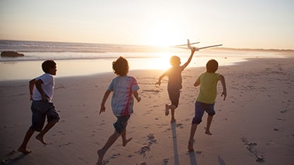 Kinder laufen und spielen am Strand