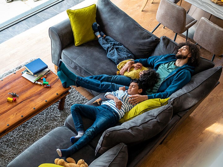 Junge Familie schläft auf der Couch