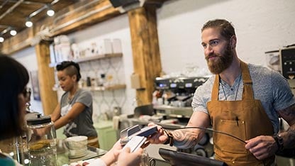 Kellner in einem Café, der eine Transaktion durchführt